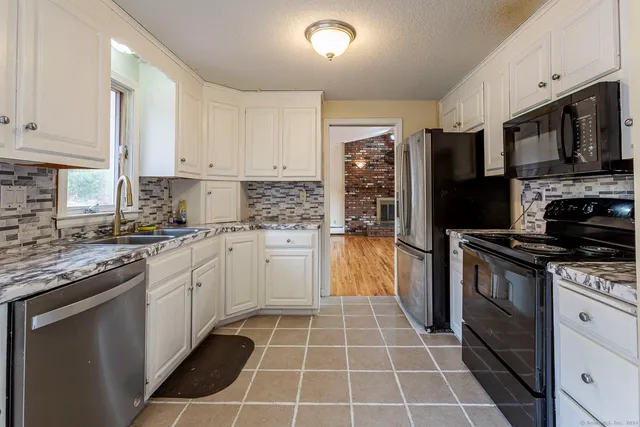 a kitchen with stainless steel appliances granite countertop a stove a sink and a refrigerator