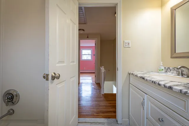 a bathroom with a granite countertop sink a mirror and shower
