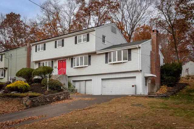 a front view of house with yard and trees in the background