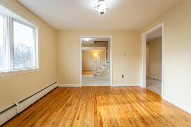a view of a room with wooden floor and a window