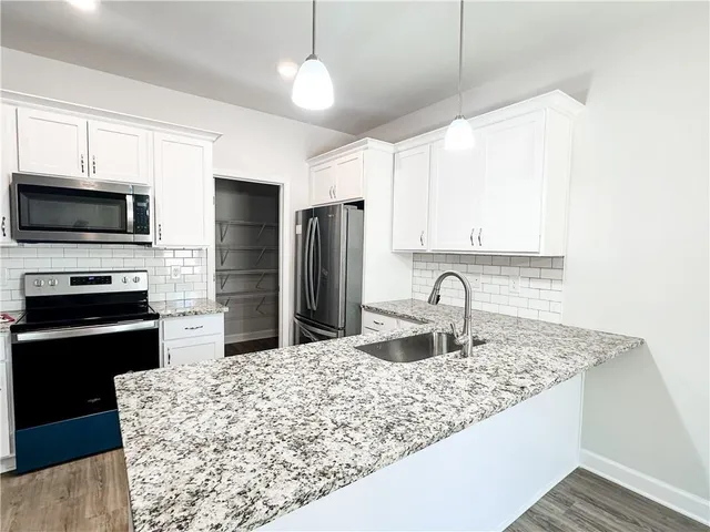 a kitchen with kitchen island granite countertop a stove microwave and refrigerator