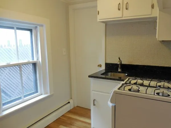 a kitchen with a stove and a window