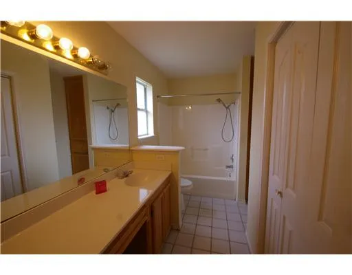 a bathroom with a sink vanity granite tub and a mirror