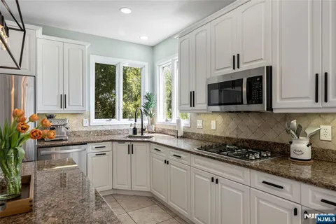 a kitchen with stainless steel appliances granite countertop a sink and cabinets