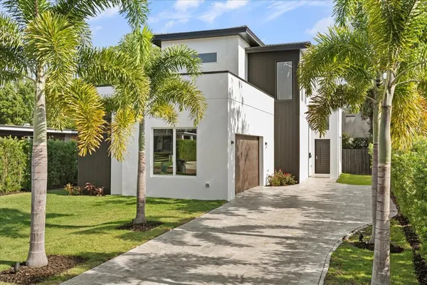 a view of a house with a yard and large tree