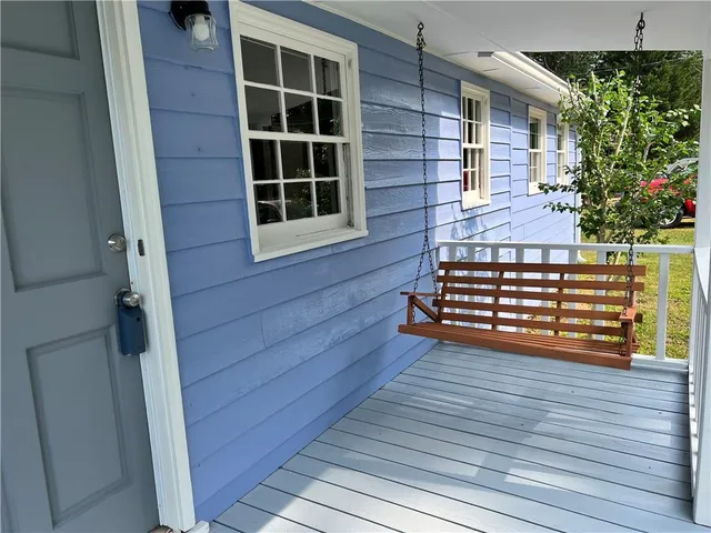 a view of front door of house with wooden floor and a yard