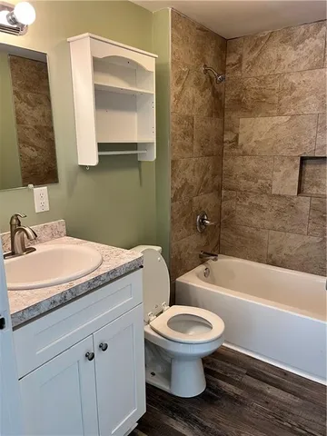 a bathroom with a granite countertop toilet a sink and bathtub