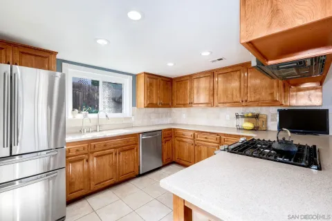 a kitchen with granite countertop a sink stainless steel appliances and cabinets