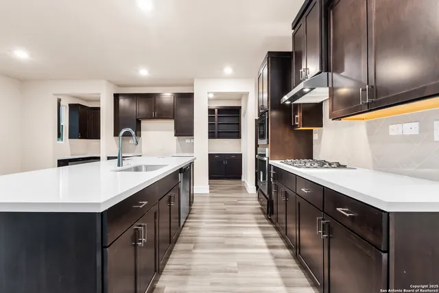 a large kitchen with stainless steel appliances kitchen island a large counter top and a sink