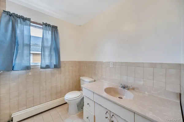 a bathroom with a granite countertop sink toilet and mirror