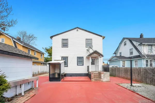 a view of a white house with large windows and a table and chairs