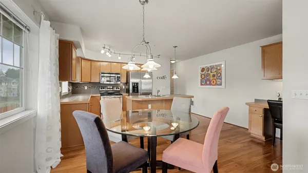 a dining room with stainless steel appliances granite countertop a dining table and chairs