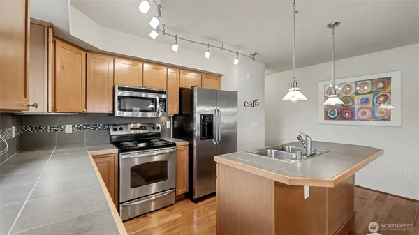 a kitchen with a sink a stove a refrigerator and a microwave