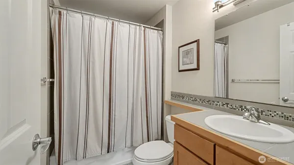 a bathroom with a sink a toilet and shower curtain