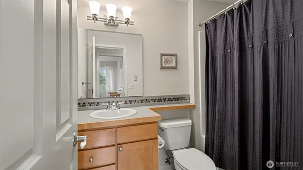 a bathroom with a sink vanity mirror and toilet