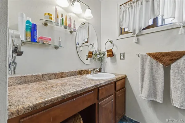 a bathroom with a granite countertop sink and a mirror