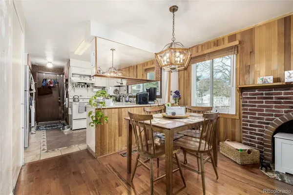 a dining room with furniture a chandelier and wooden floor