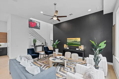 a living room with furniture potted plants and a flat screen tv
