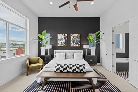 a bedroom with a bed lamp and a potted plant