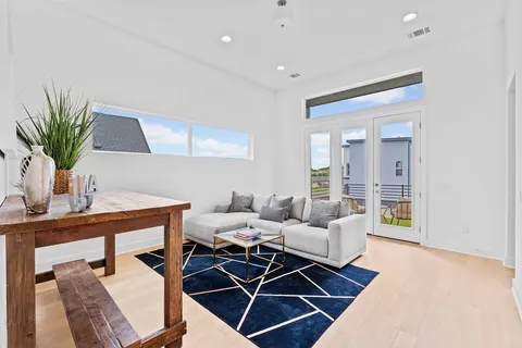 a living room with furniture a dining table and a potted plant