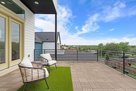 a view of a balcony with table and chairs and wooden fence