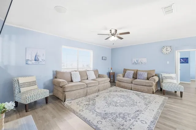 a living room with furniture ceiling fan and a rug