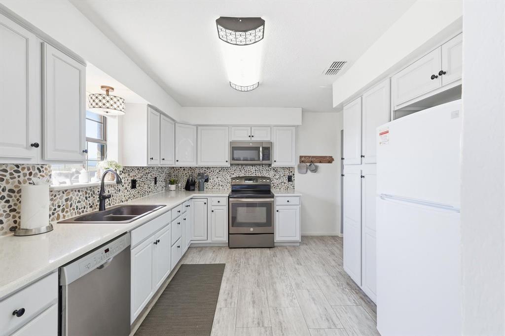 3873 Lois Road East Sanger, TX 76266 - Photo 17 of 40 a kitchen with white cabinets and white appliances