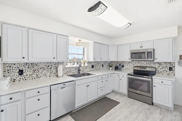 a kitchen with granite countertop white cabinets and white appliances