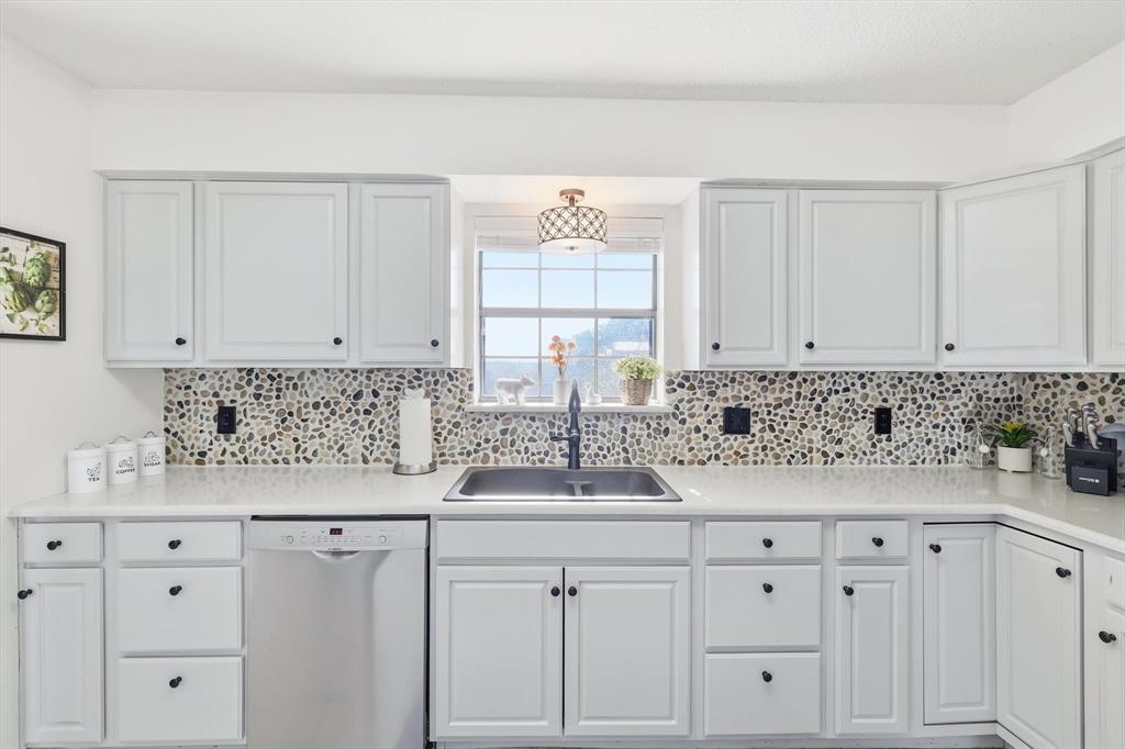 3873 Lois Road East Sanger, TX 76266 - Photo 20 of 40 a kitchen with granite countertop white cabinets and a sink