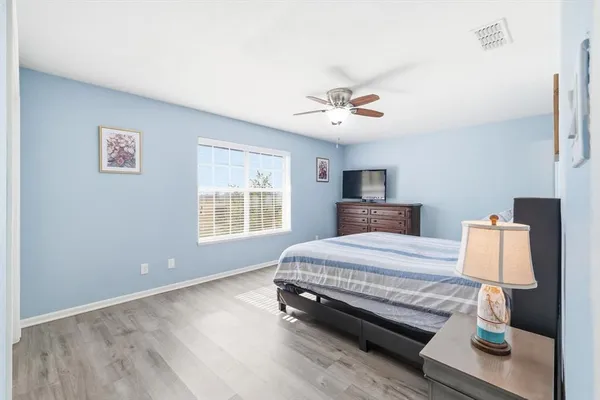 a spacious bedroom with a bed and a chandelier