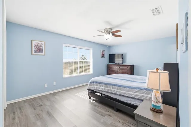a spacious bedroom with a bed and a chandelier