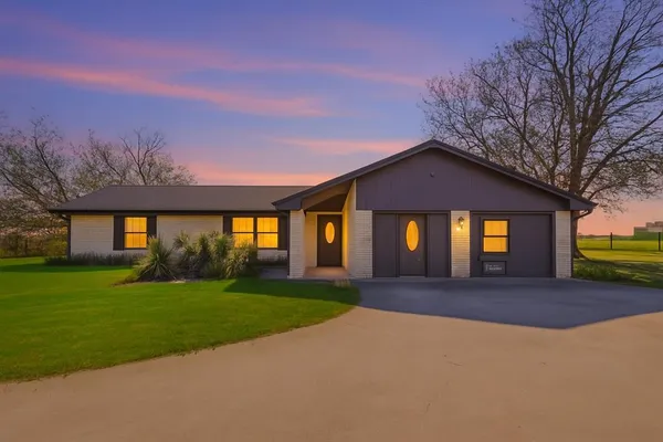 a front view of a house with a yard and entertaining space