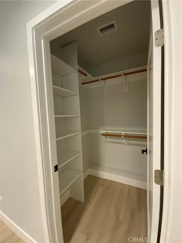 a view of walk in closet with empty racks