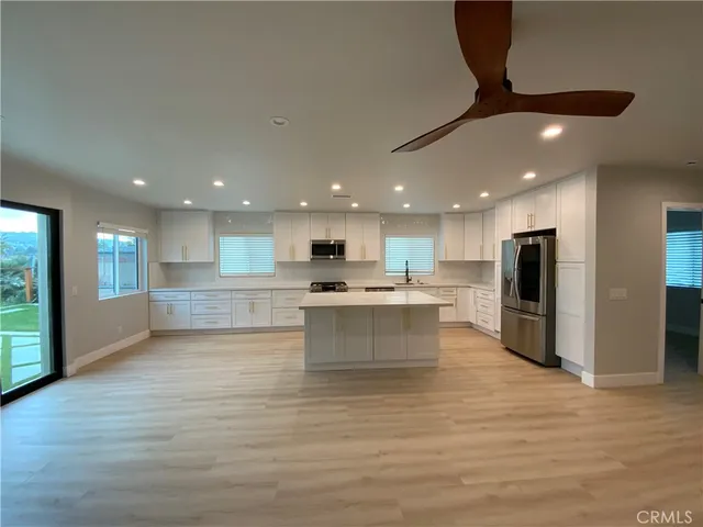 a kitchen with stainless steel appliances granite countertop a stove a sink and a refrigerator