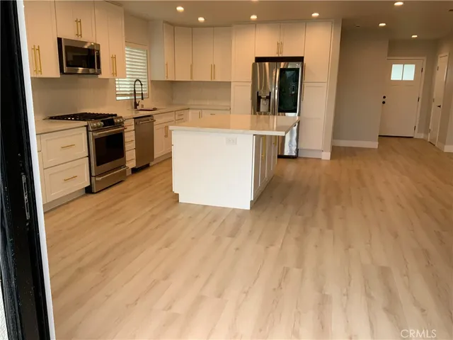 a kitchen with stainless steel appliances granite countertop a sink and a stove