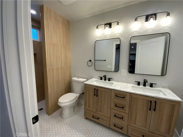 a bathroom with a double vanity sink mirror and toilet