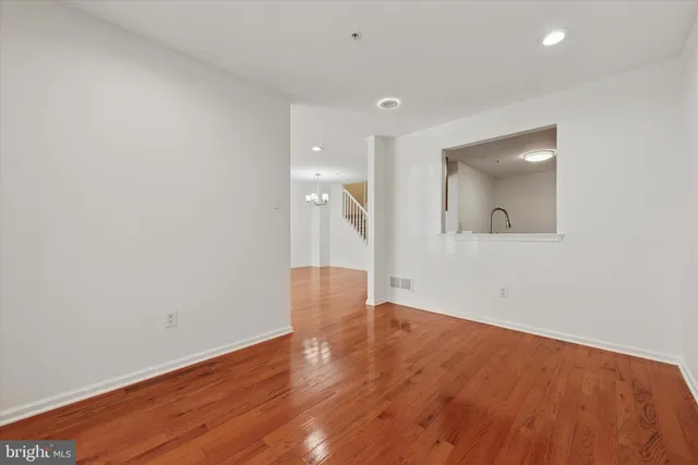 an empty room with wooden floor and mirror