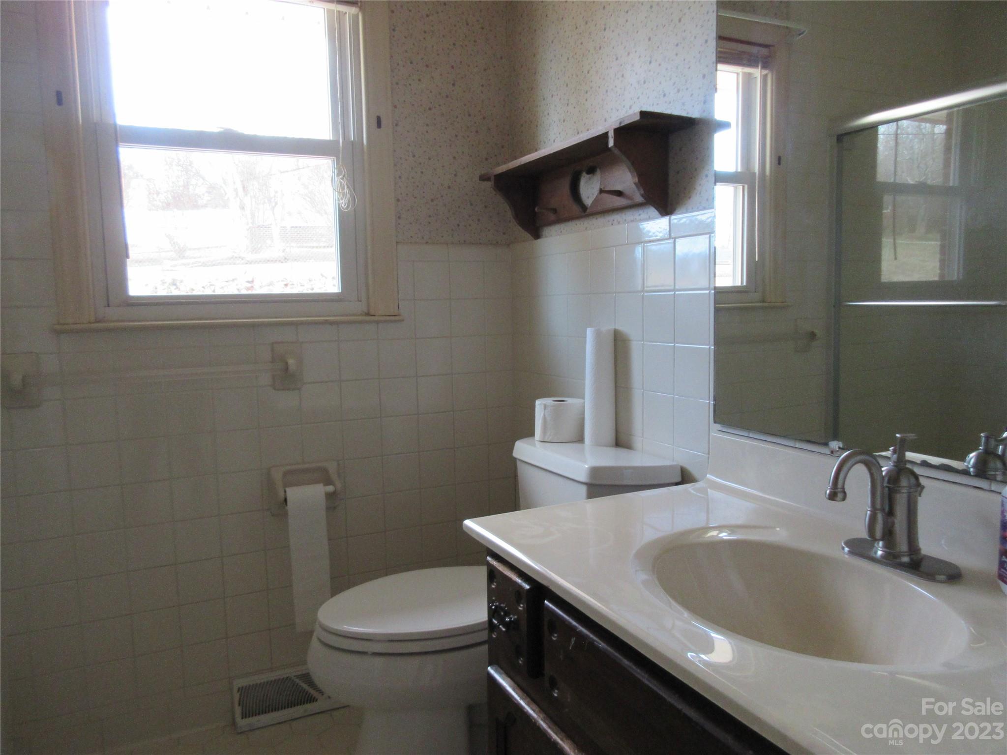 145 Hodge Street Rutherfordton, NC 28139 - Photo 13 of 24 a bathroom with a granite countertop toilet sink and mirror