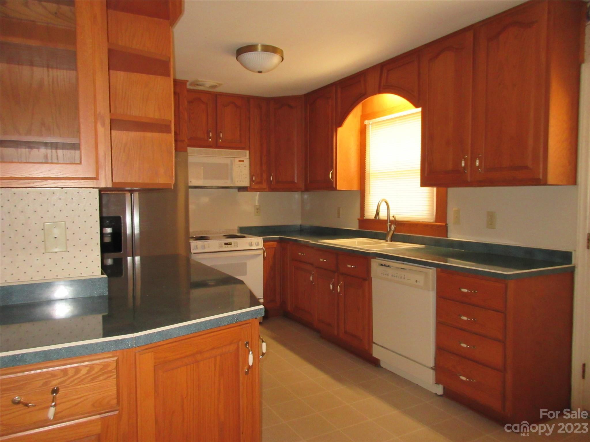 145 Hodge Street Rutherfordton, NC 28139 - Photo 8 of 24 a kitchen with stainless steel appliances granite countertop a sink a stove and a refrigerator