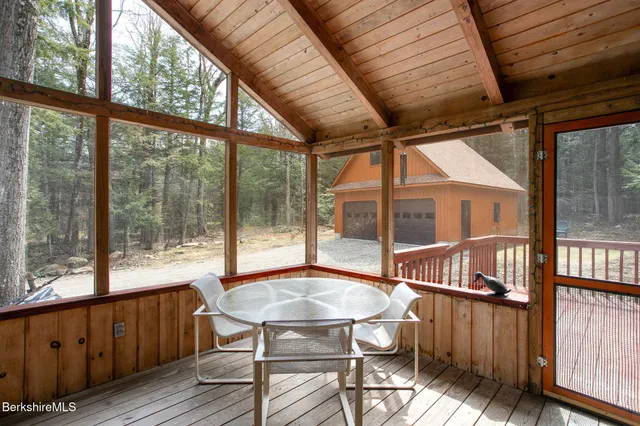a view of a porch with furniture and wooden floor