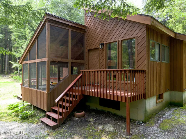 a view of wooden house with a yard from a balcony