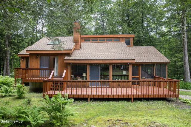 a view of a house with a backyard and deck