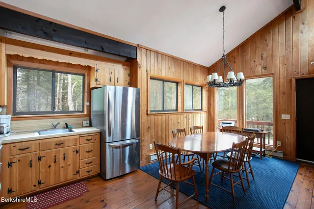a kitchen with stainless steel appliances granite countertop a table chairs and wooden floors