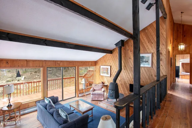 a living room with furniture a large window and wooden floor