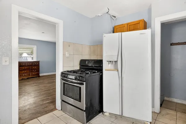 a white refrigerator freezer and a stove sitting inside of a kitchen