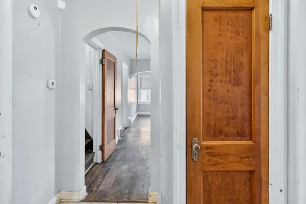 a hallway with wooden floor and closet