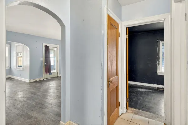 a view of an empty room with closet and a mirror