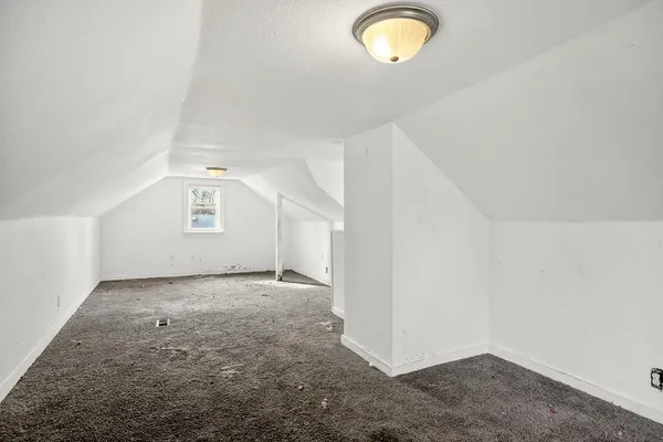 an empty room with cabinet and windows