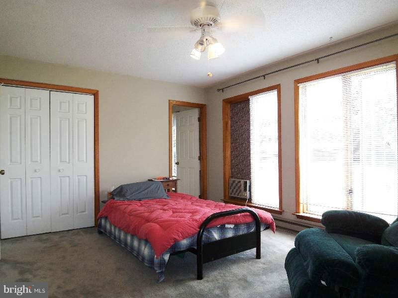 667 Morgan Grove Road Shepherdstown, WV 25443 - Photo 24 of 30 a spacious bedroom with a bed and a couch next to a window