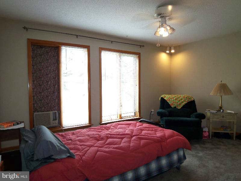 667 Morgan Grove Road Shepherdstown, WV 25443 - Photo 26 of 30 a bedroom with a bed and a chandelier